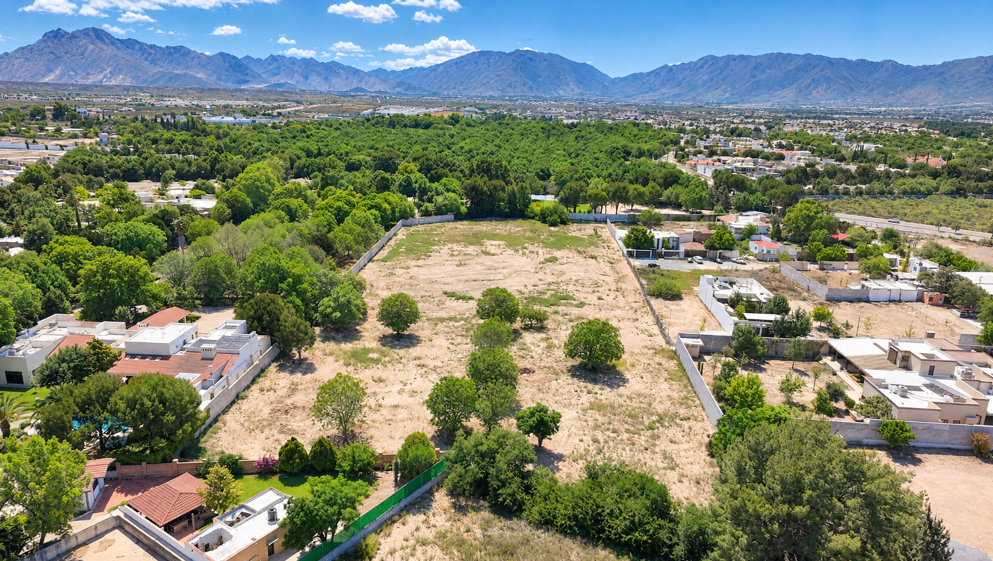 Vista aérea del terreno de Solvay y su entorno residencial, con montañas al fondo